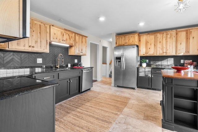 kitchen with sink, appliances with stainless steel finishes, dark stone countertops, backsplash, and gray cabinetry