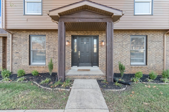 property entrance featuring a lawn