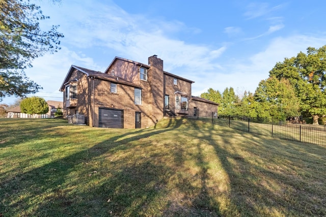 rear view of house featuring a yard and a garage