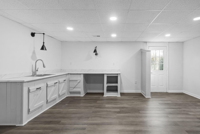 bar with sink, pendant lighting, white cabinets, and dark wood-type flooring