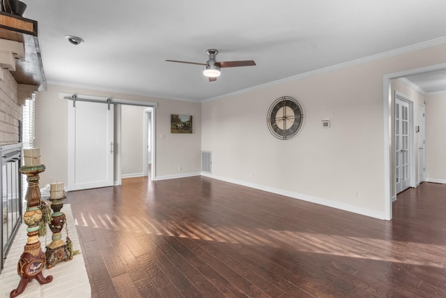 unfurnished living room with dark hardwood / wood-style flooring, crown molding, a barn door, and ceiling fan