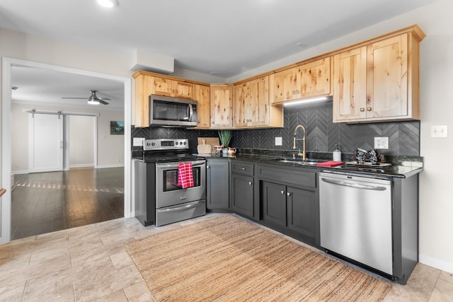 kitchen with sink, appliances with stainless steel finishes, gray cabinetry, tasteful backsplash, and dark stone counters