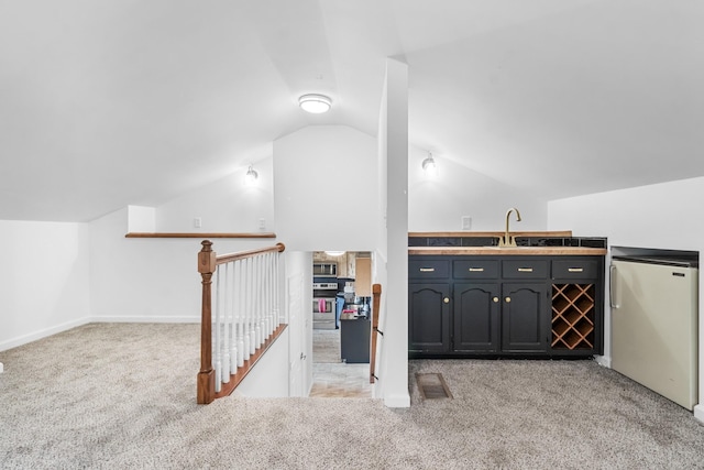 additional living space with lofted ceiling, sink, and light carpet