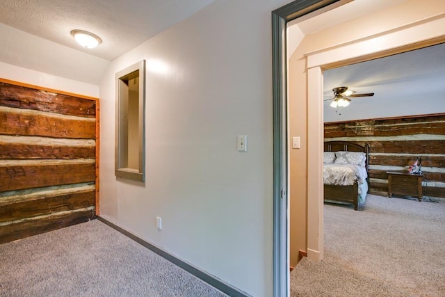 corridor with light colored carpet and wood walls