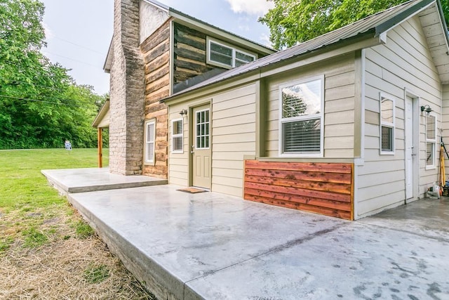 view of side of property featuring a patio and a lawn