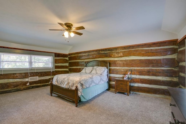 carpeted bedroom with vaulted ceiling and wooden walls