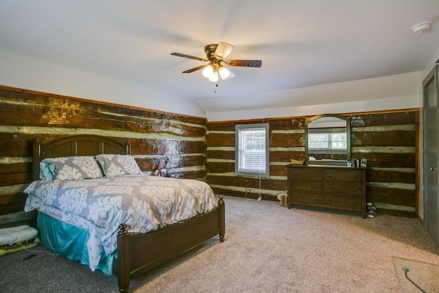 bedroom featuring ceiling fan, wooden walls, lofted ceiling, and carpet flooring