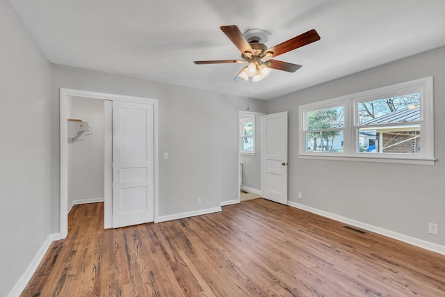 unfurnished bedroom with hardwood / wood-style flooring, ceiling fan, and a closet