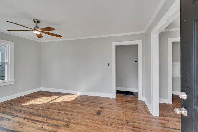 empty room with hardwood / wood-style flooring, ceiling fan, and crown molding