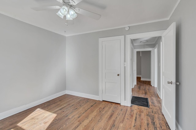 spare room with crown molding, wood-type flooring, and ceiling fan