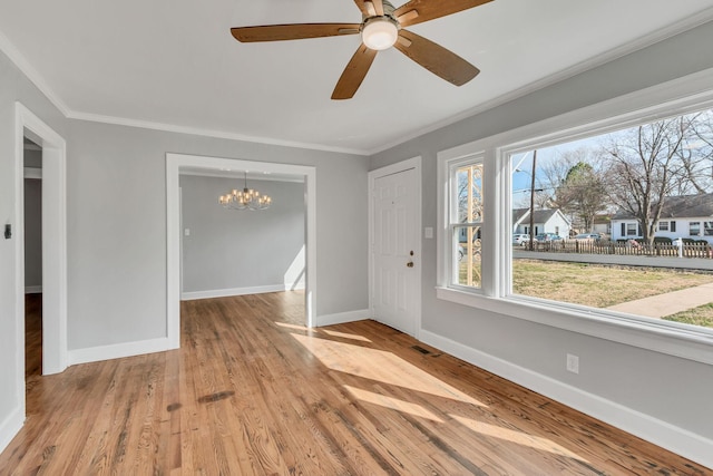 interior space featuring ceiling fan with notable chandelier, ornamental molding, and light hardwood / wood-style floors