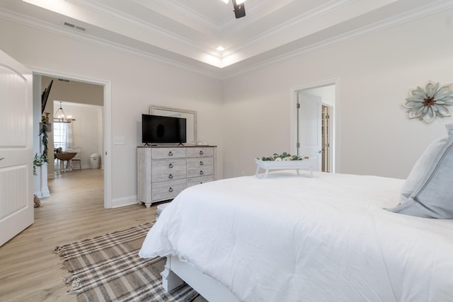 bedroom with ceiling fan with notable chandelier, light hardwood / wood-style flooring, ornamental molding, and a raised ceiling