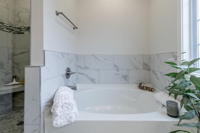 bathroom featuring shower with separate bathtub