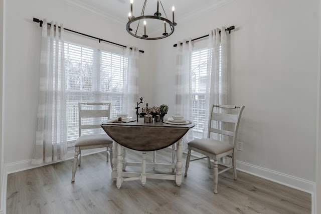 dining room featuring crown molding, a chandelier, and light hardwood / wood-style flooring