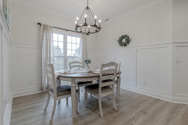 dining room featuring a notable chandelier, crown molding, and light hardwood / wood-style flooring