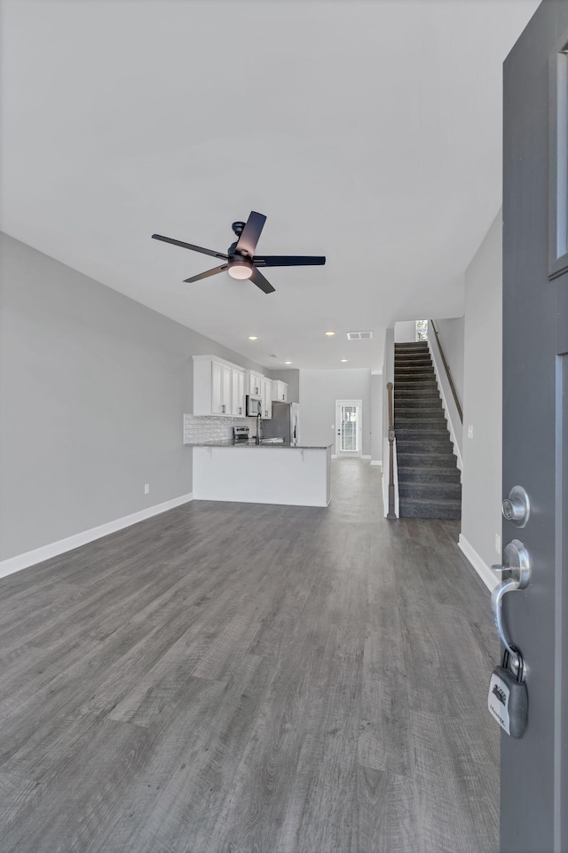 unfurnished living room with hardwood / wood-style flooring and ceiling fan