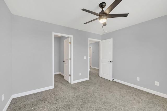 unfurnished bedroom with a spacious closet, light colored carpet, and ceiling fan