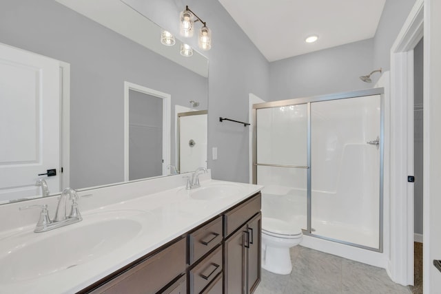 bathroom featuring vanity, a shower with shower door, and toilet