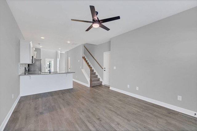 unfurnished living room with hardwood / wood-style floors and ceiling fan