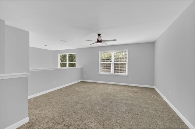 carpeted empty room featuring a wealth of natural light and ceiling fan