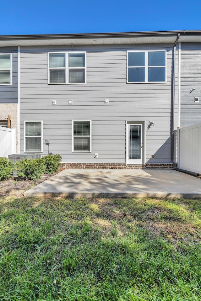 rear view of house with a patio area and a lawn