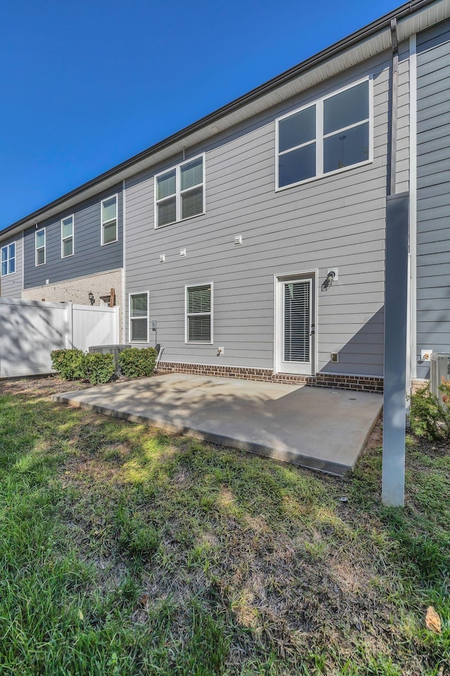 back of property featuring a patio area and a lawn