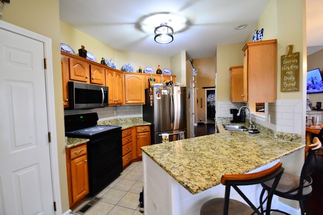 kitchen with black range with electric stovetop, sink, stainless steel refrigerator, and kitchen peninsula