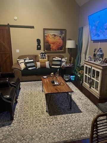 living room with vaulted ceiling and a barn door