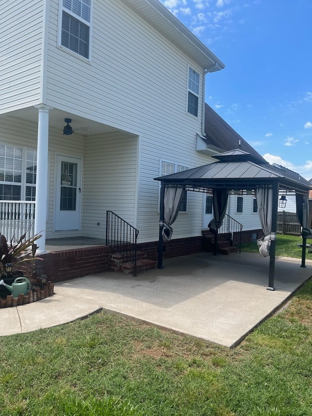 back of property featuring a gazebo and a lawn