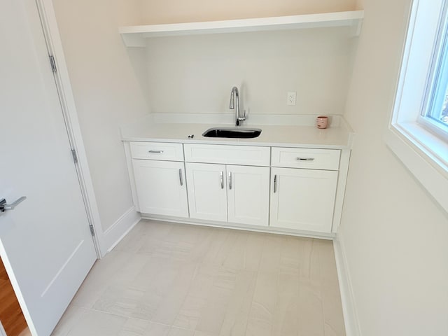 interior space featuring white cabinetry and sink