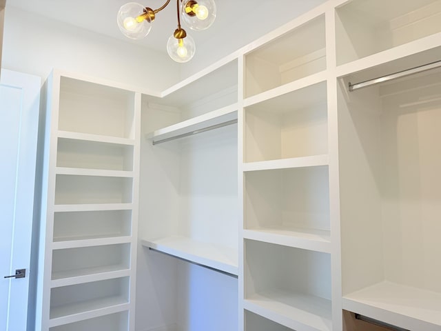 walk in closet featuring a notable chandelier