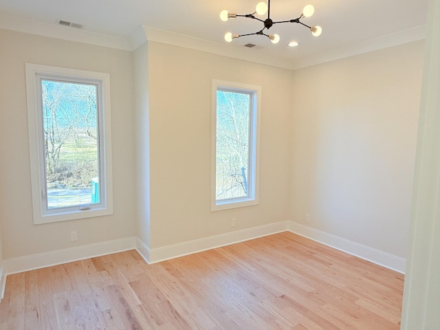 unfurnished room with ornamental molding, light hardwood / wood-style flooring, and a notable chandelier