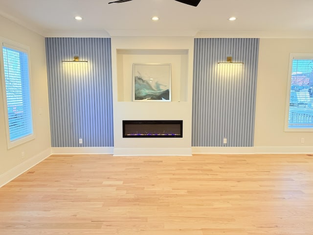 unfurnished living room featuring crown molding, ceiling fan, and light wood-type flooring