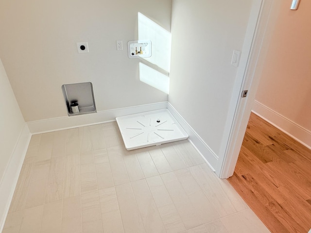 clothes washing area with wood-type flooring, hookup for an electric dryer, and washer hookup