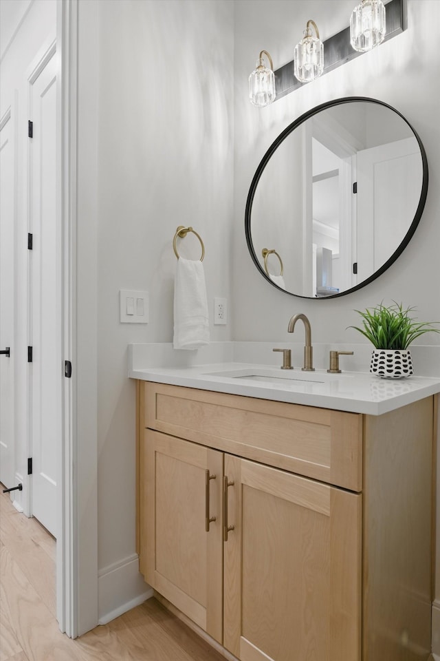 bathroom featuring wood finished floors, vanity, and baseboards