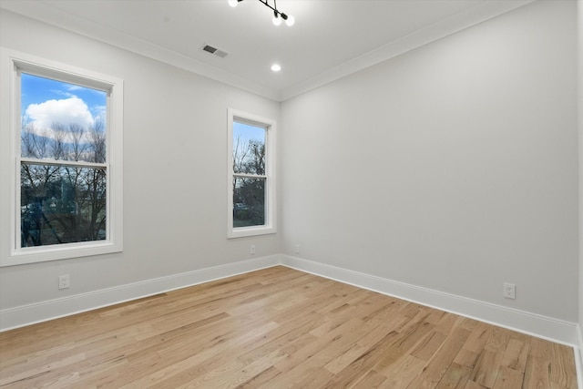 empty room featuring ornamental molding, light wood-type flooring, recessed lighting, and baseboards