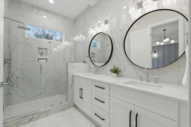 bathroom with double vanity, marble finish floor, a marble finish shower, and a sink