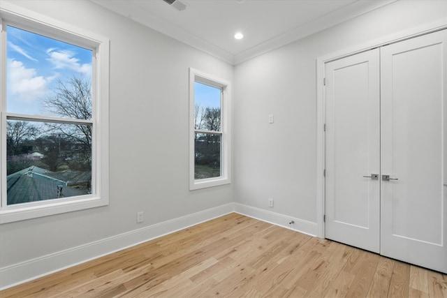 unfurnished bedroom featuring crown molding, light wood finished floors, recessed lighting, a closet, and baseboards