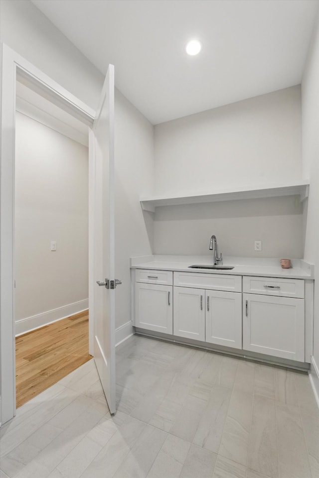 bar with baseboards and a sink