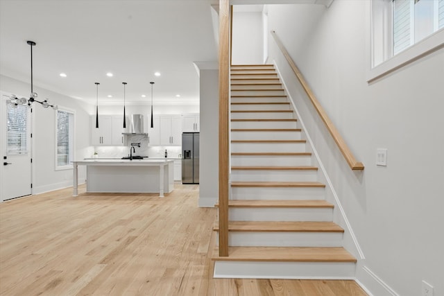 staircase with baseboards, wood finished floors, and recessed lighting