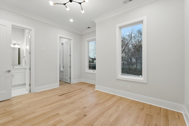 unfurnished bedroom featuring an inviting chandelier, ornamental molding, ensuite bathroom, light wood-type flooring, and baseboards