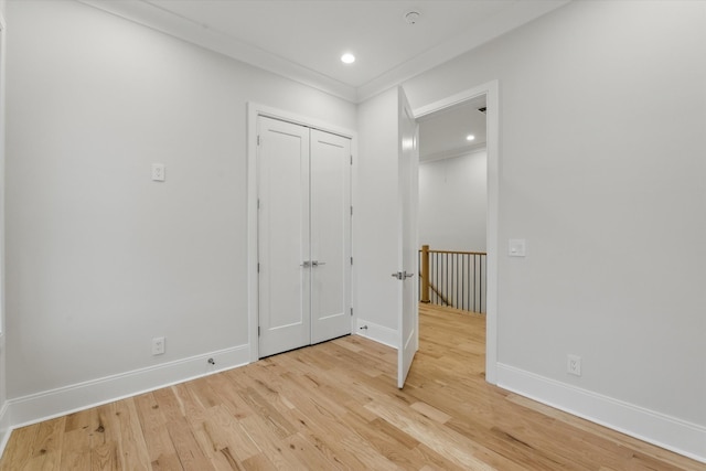 empty room featuring light wood-type flooring, baseboards, crown molding, and recessed lighting