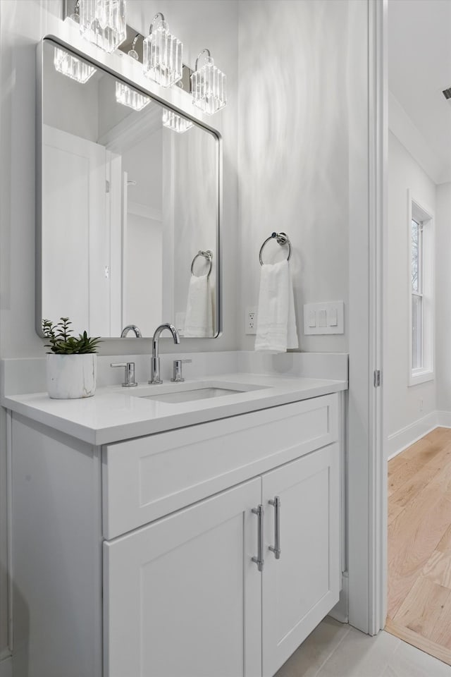 bathroom featuring baseboards, wood finished floors, and vanity