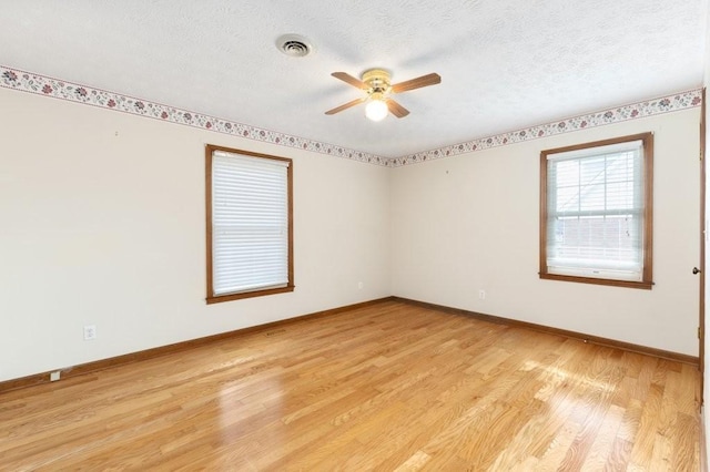 empty room featuring ceiling fan, a textured ceiling, and light wood-type flooring