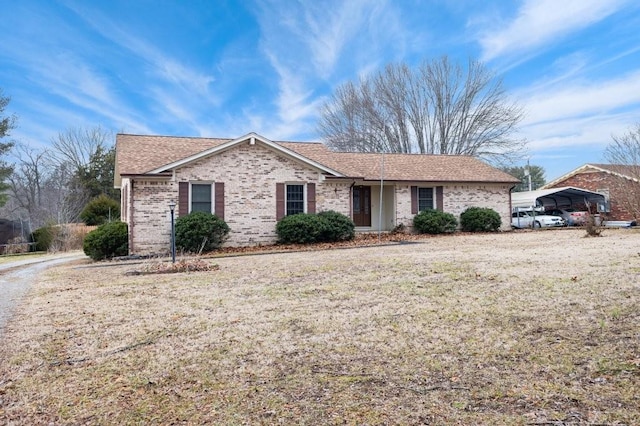 ranch-style home featuring a front lawn and a carport