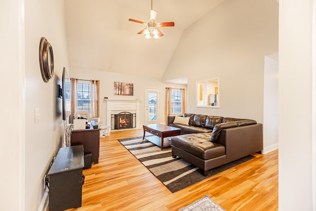 living room with ceiling fan, wood-type flooring, and high vaulted ceiling