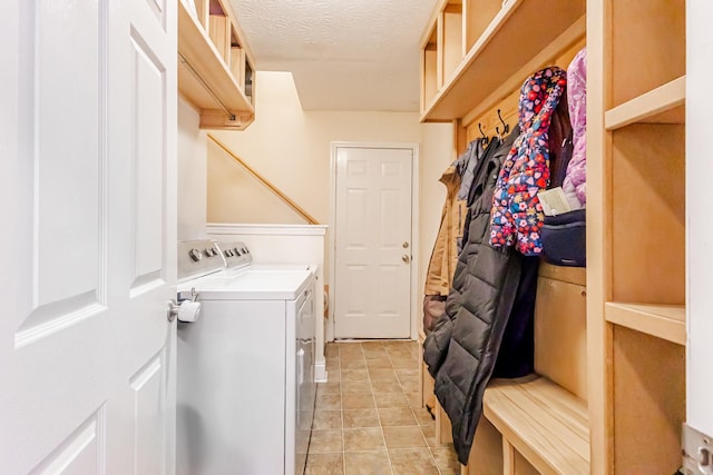 clothes washing area with washer and dryer and a textured ceiling