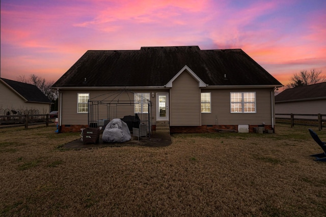 back house at dusk with a gazebo and a lawn