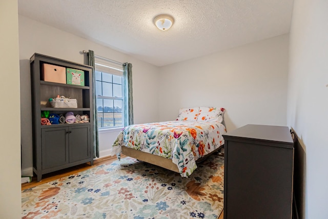 bedroom with hardwood / wood-style floors and a textured ceiling