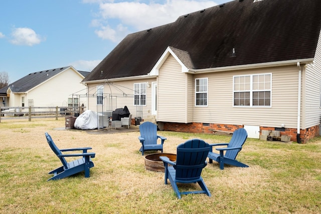 back of property with a fire pit, a lawn, and a gazebo